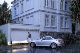 Woman standing in the rain opening garage door